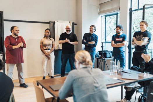 A diverse group of adults engaging in a casual team meeting indoors.